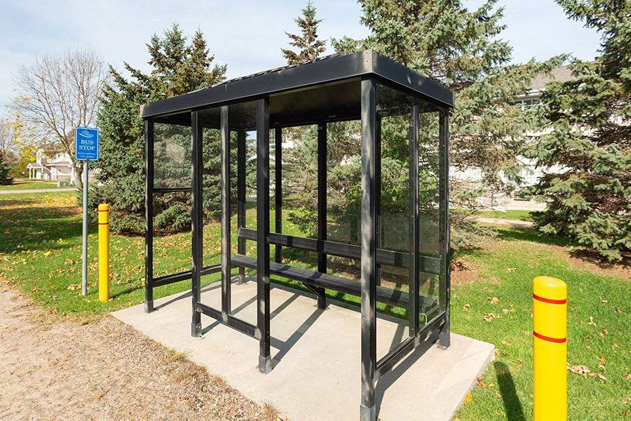 a bus stop with a bench in a park