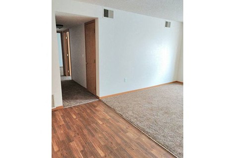 an empty living room with white walls and wood floors