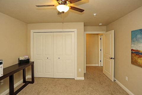 a living room with a ceiling fan and a closet
