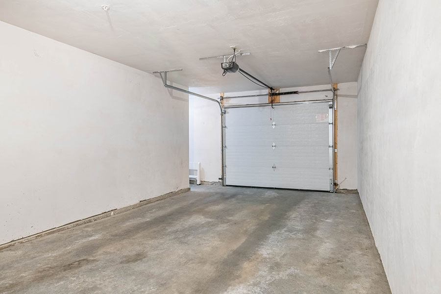 an empty garage with a white wall and a garage door