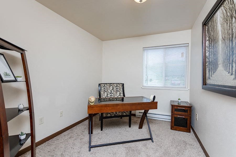 a room with a desk and a chair and a window