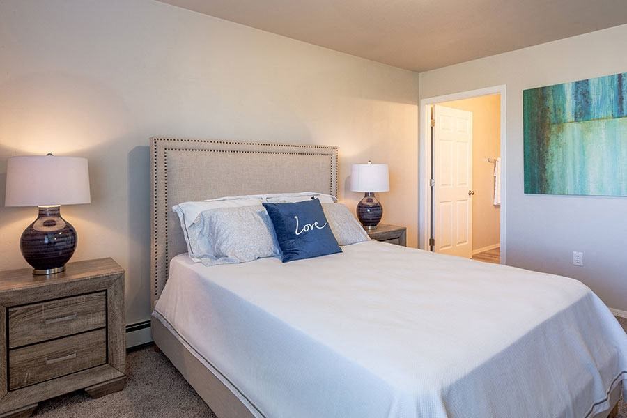 a bedroom with a white bed and two lamps
