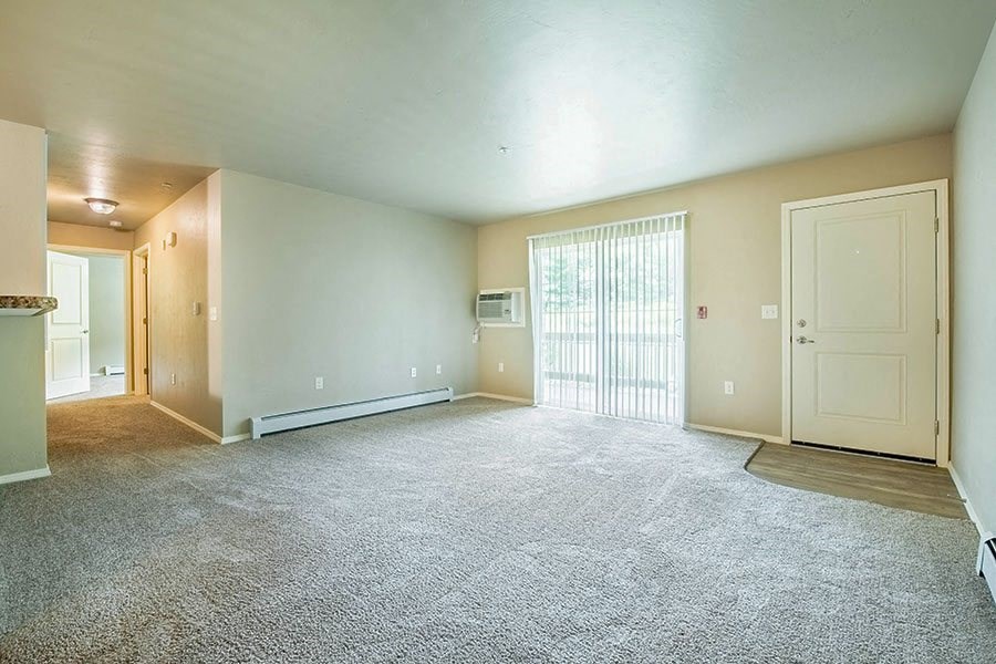 an empty living room with a sliding glass door