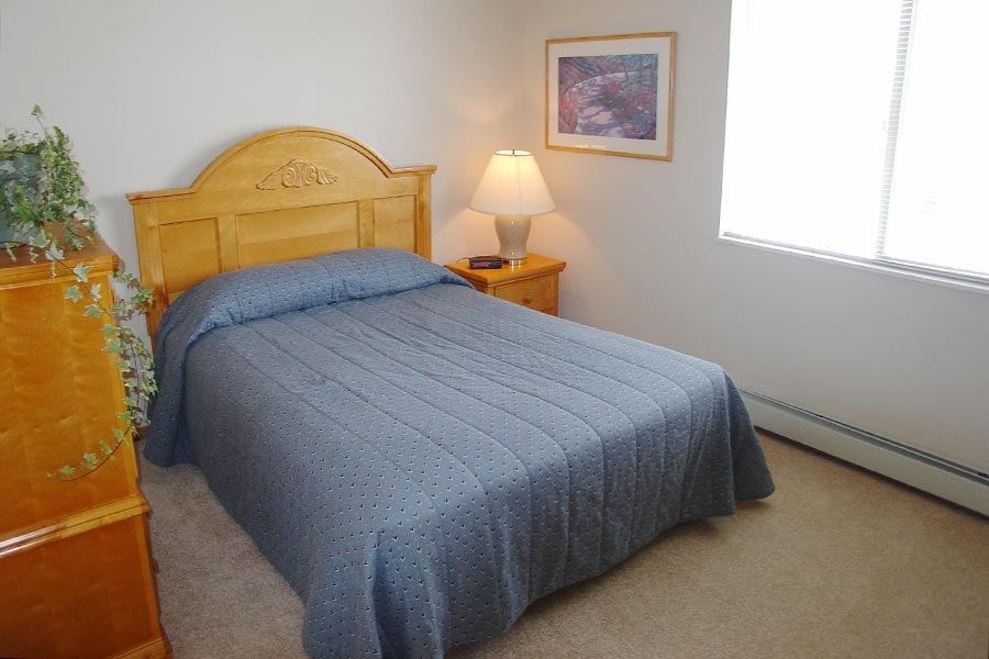 a bedroom with a bed with a blue comforter