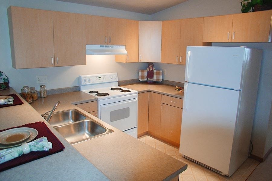 a kitchen with a white refrigerator and a sink