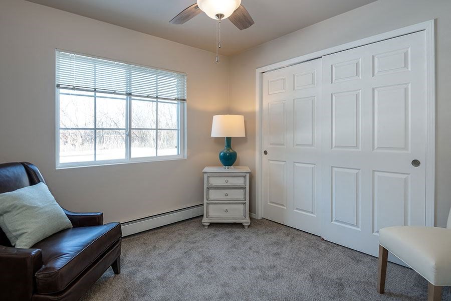 a living room with a leather chair and a white door