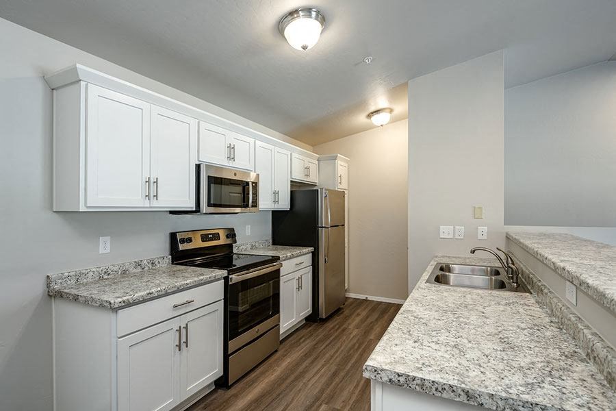 a kitchen with granite counter tops and white cabinets