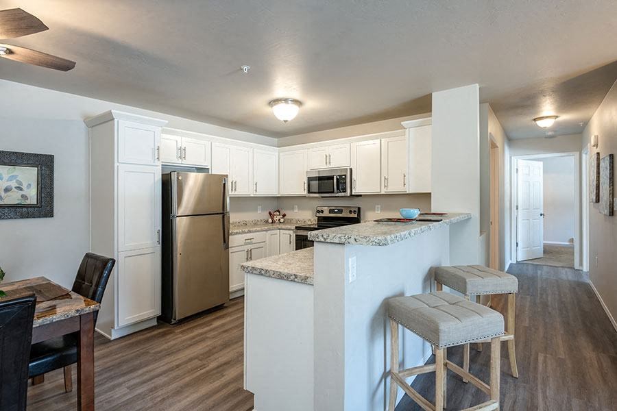 a kitchen with a bar and a stainless steel refrigerator