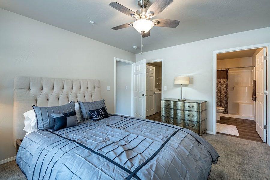 a bedroom with a large bed and a ceiling fan