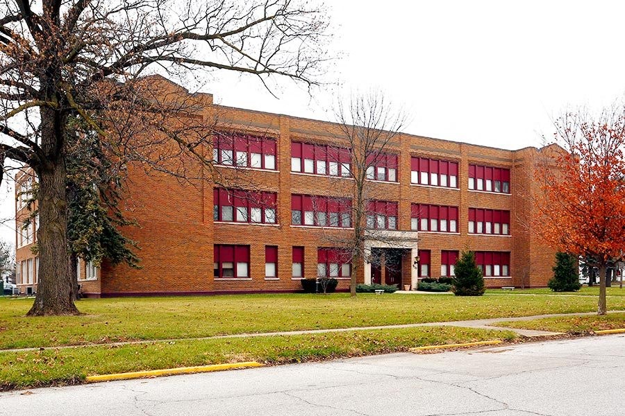 a large brick building with a lawn in front of it