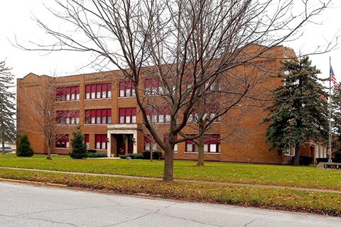 a large brick building with a tree in front of it