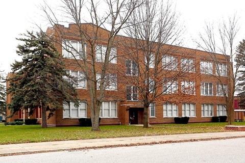a large brick building with trees in front of it