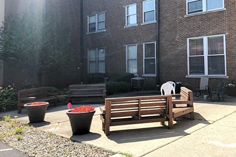 two wooden benches in front of a brick building