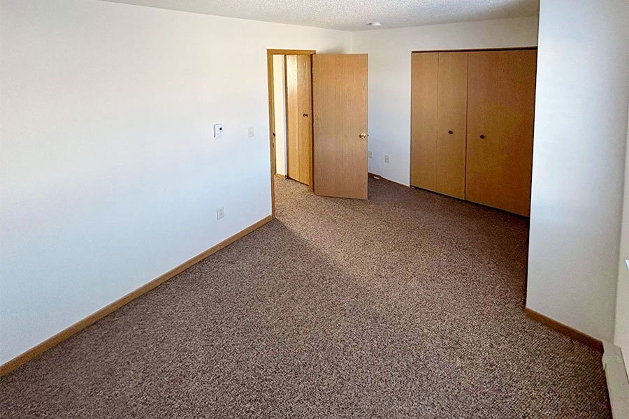 an empty room with carpet and doors