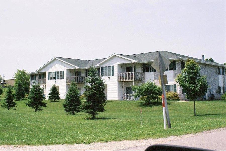a white house with a yard and trees in front of it