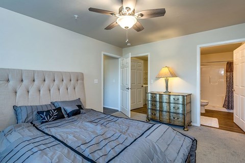 A bedroom with a large bed and a ceiling fan.
