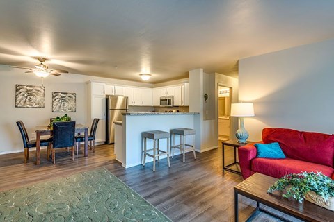 A modern living room with a red couch and a dining table set up.