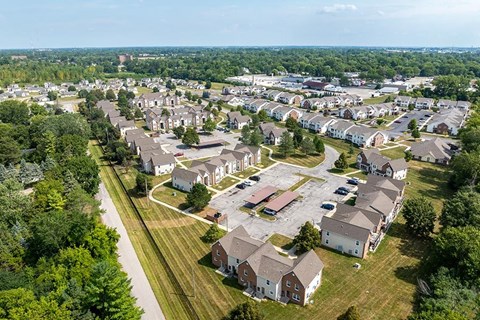A bird's eye view of a residential area with houses and a parking lot.