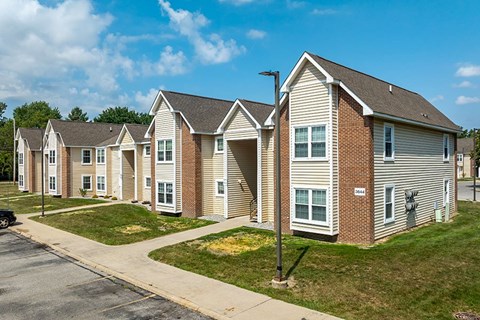 A row of houses with a car parked in front of them.