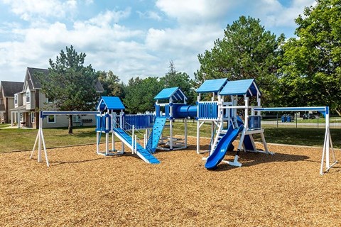 A playground with a blue slide and a blue roofed structure.