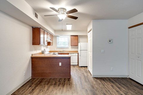 A kitchen with a wooden island and a ceiling fan.