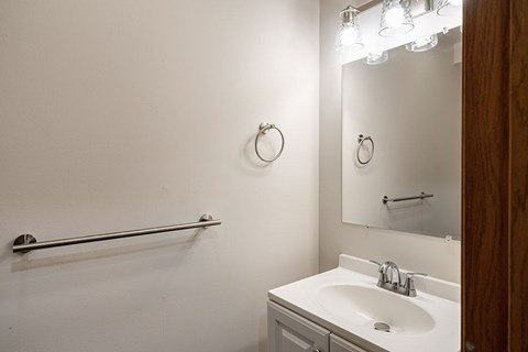 A white bathroom with a sink and a mirror.