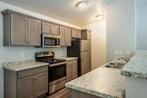 A kitchen with granite countertops and stainless steel appliances.