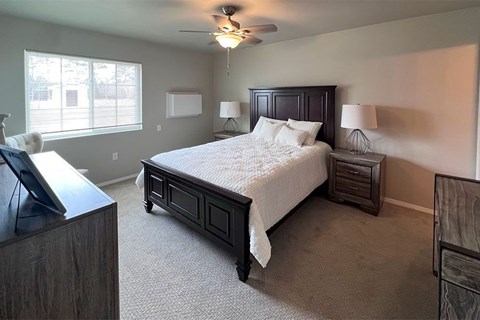 A bedroom with a large bed and a flat screen TV.