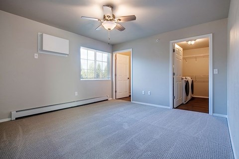 A room with a ceiling fan and a window.