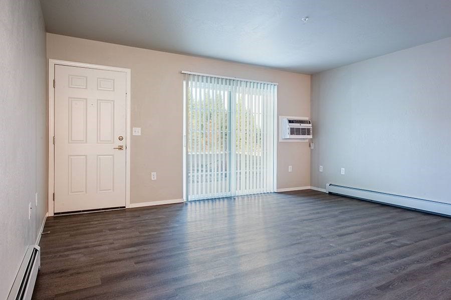 A room with a white door and a window with blinds.