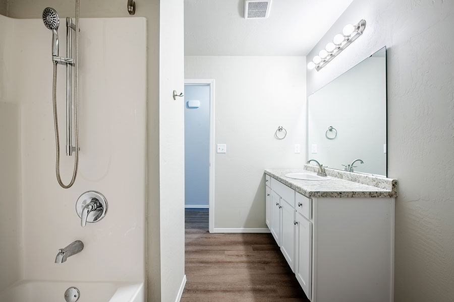 A bathroom with a white sink and a white shower.