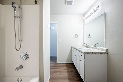 A bathroom with a white sink and a white shower.