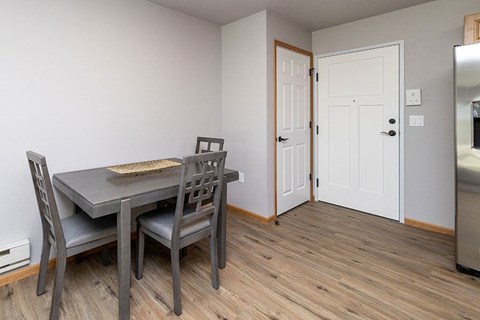 A kitchen with a table and chairs.