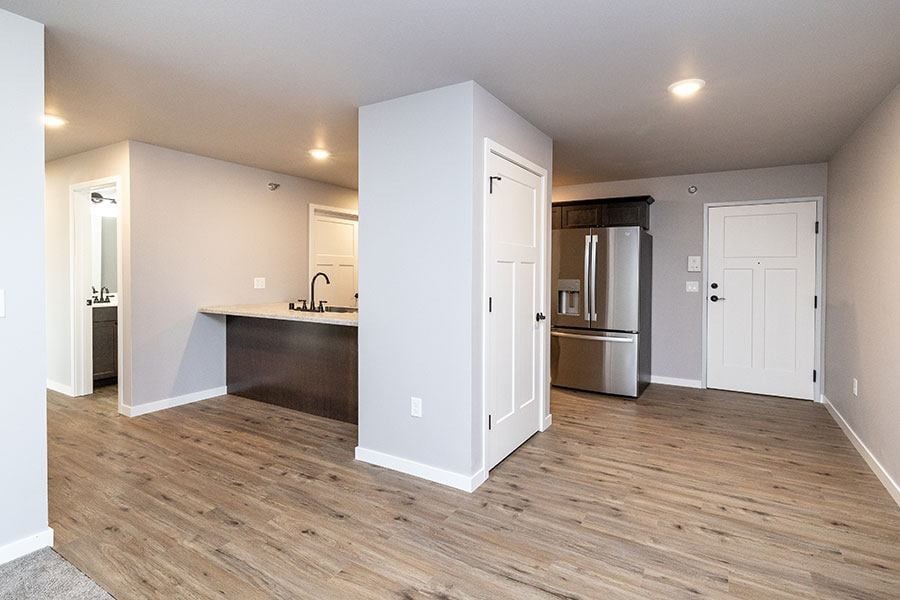 A kitchen area with a sink and a refrigerator.