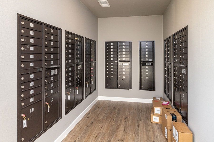 A room with a wall of mailboxes and a few boxes on the floor.