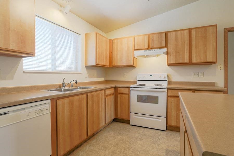 an empty kitchen with a stove and a sink