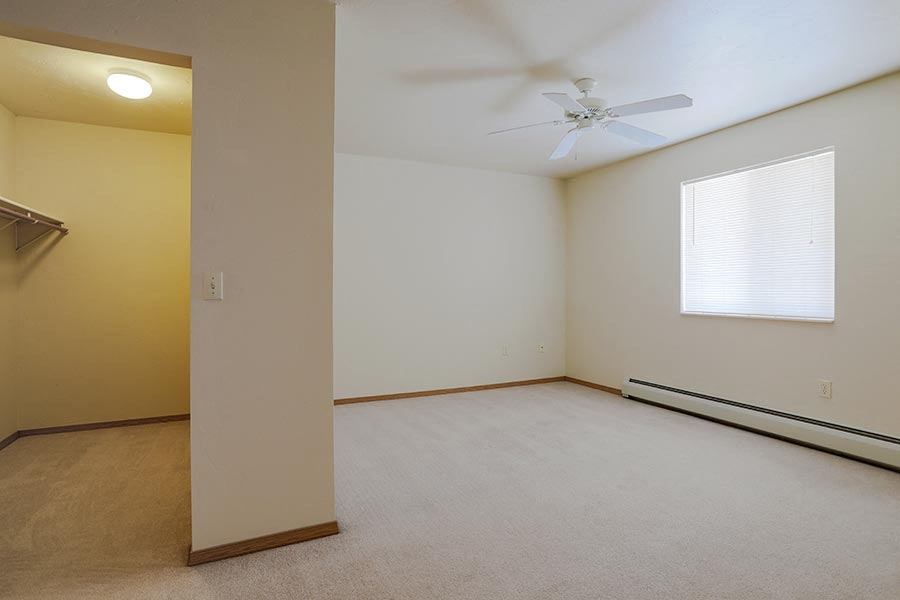 an empty room with a ceiling fan and a window