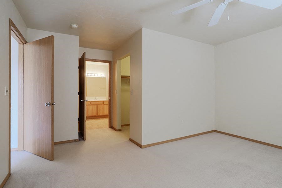 an empty living room with a door to a bathroom