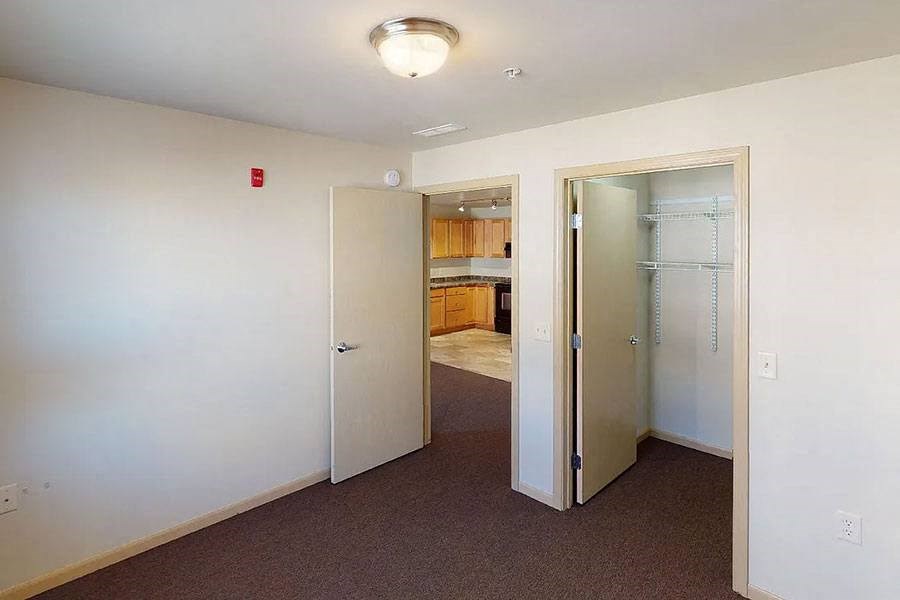 an empty room with a door to a kitchen