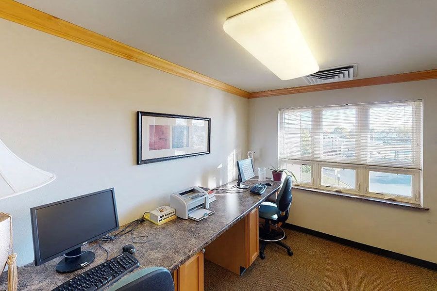 a room with a desk with a computer and a monitor