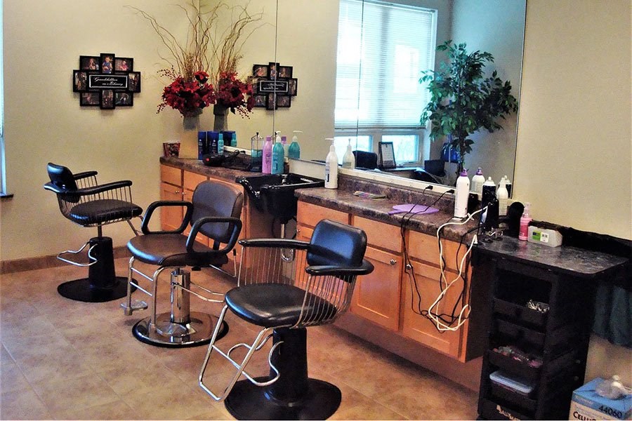 a hair salon with three black chairs and a counter