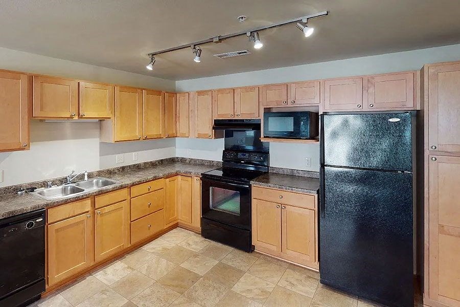 a kitchen with black appliances and wooden cabinets