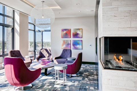 a living room with purple chairs and a fireplace