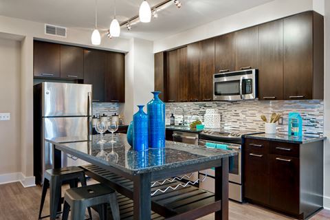 a kitchen with stainless steel appliances and a table with blue vases