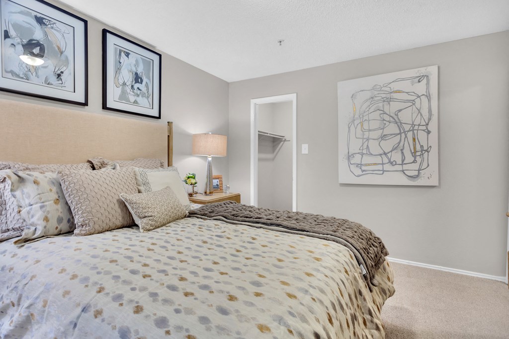 a bedroom with a bed and pictures on the wall