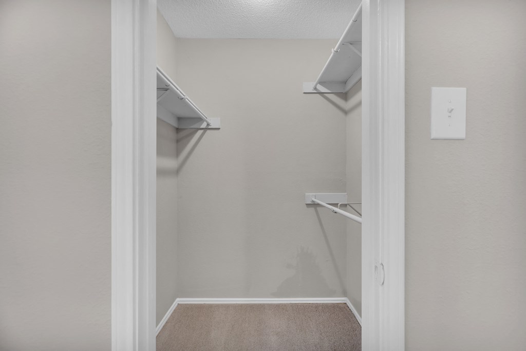 an empty closet in a home with empty shelves
