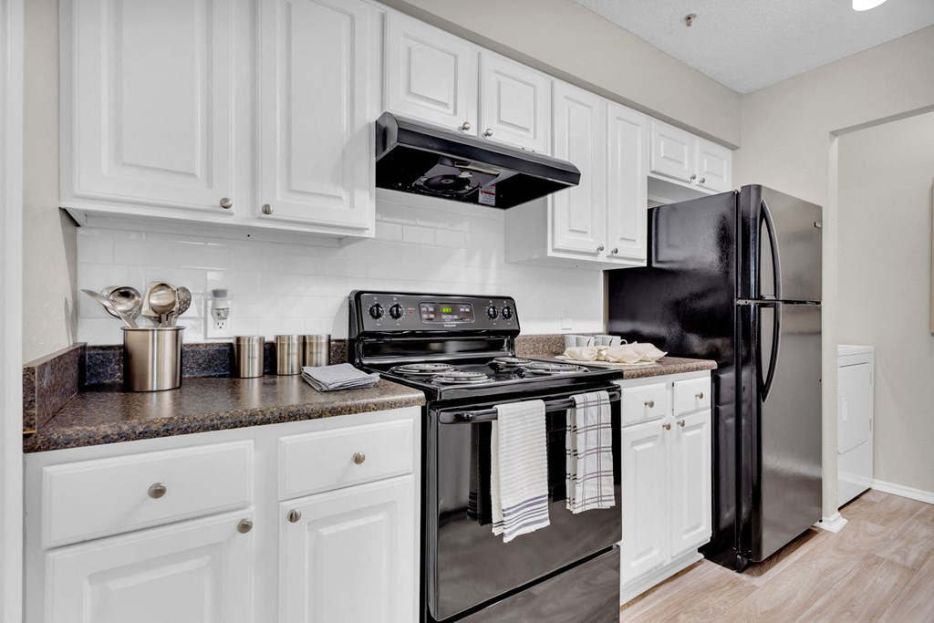 a kitchen with stainless steel appliances and white cabinets