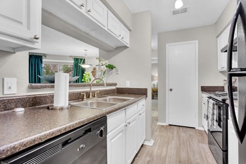 a kitchen with granite counter tops and a stainless steel sink