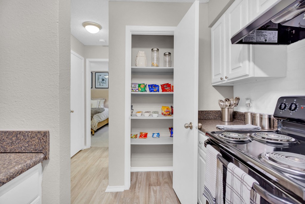 a kitchen with white cabinets and a stove and a refrigerator
