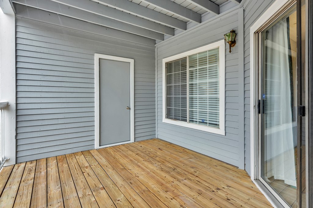 the deck of a home with a door and a window